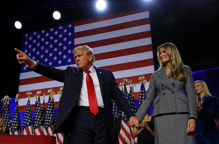 REUTERS/BRIAN SNYDER
                                Republican presidential nominee and former President Donald Trump gestures as he holds hands with his wife Melania during his rally, at the Palm Beach County Convention Center in West Palm Beach, Fla.