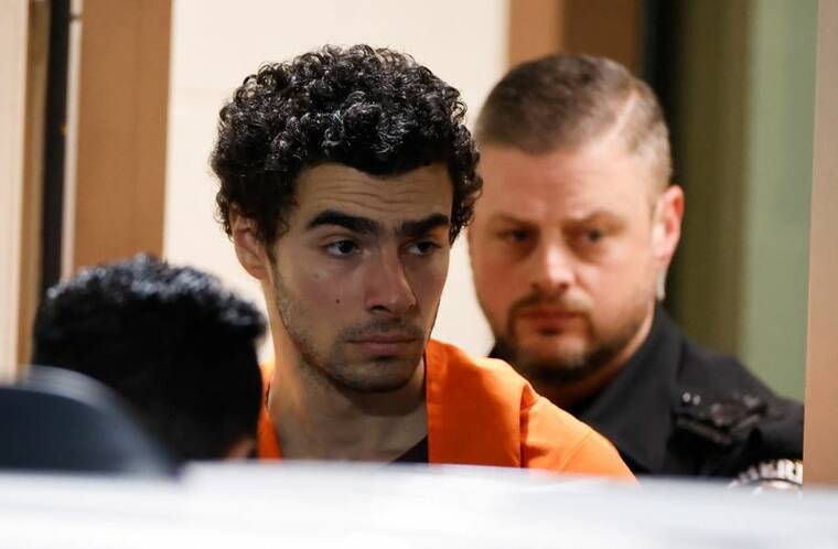 EDUARDO MUNOZ / REUTERS
                                Luigi Mangione, 26, the suspect in the New York City killing of UnitedHealthcare chief executive Brian Thompson, is escorted after an extradition hearing at Blair County Court House in Hollidaysburg, Pennsylvania, on Dec. 10. He was charged with murder and other offenses today in New York.