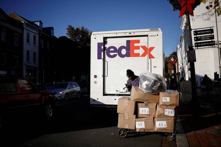 REUTERS/BENOIT TESSIER/FILE PHOTO
                                A FedEx driver of stands with packages near a delivery truck during Black Friday preparations in the Georgetown neighborhood of Washington, on Nov. 26.