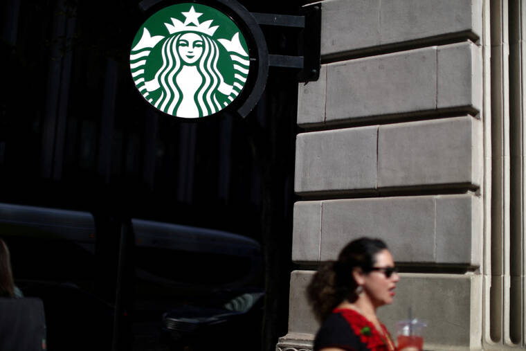 REUTERS/LUCY NICHOLSON / 2018
                                A woman holds a drink outside a Starbucks store in Los Angeles, Calif.