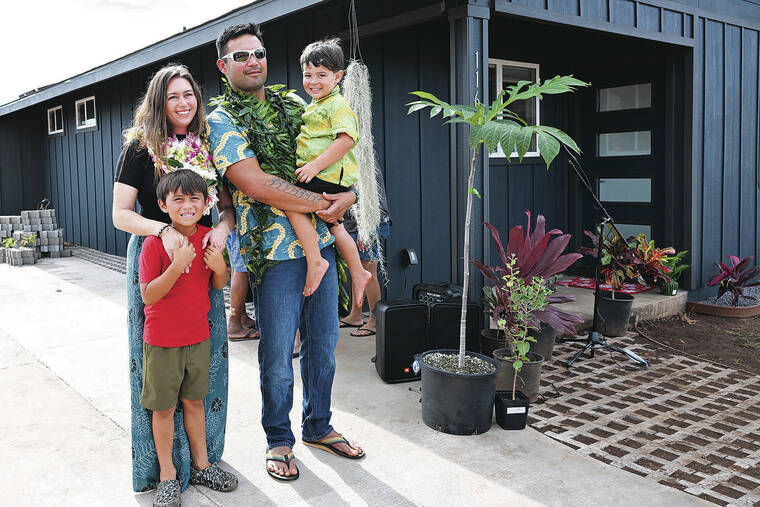 ANDREW VLIET / SPECIAL TO THE STAR-ADVERTISER
                                The Ah Hee family stand in the driveway of their new home in Lahaina before a small blessing ceremony Friday before family, co-workers and contractors who made it possible to rebuild.