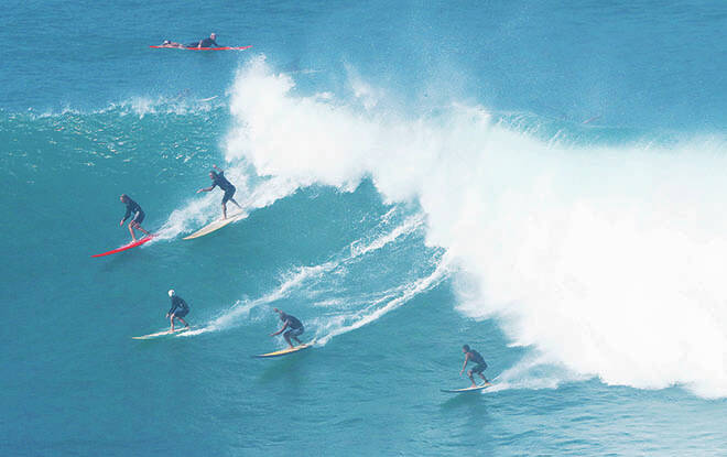 JAMM AQUINO / JAQUINO@STARADVERTISER.COM
                                Surfers take off on a wave at Waimea Bay Friday on Oahu’s North Shore.