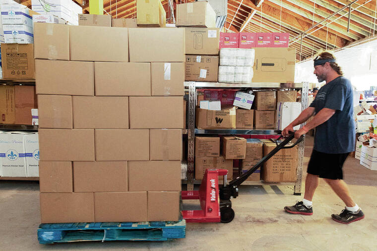 STAR-ADVERTISER / 2023
                                A worker at the Kahana Gateway distribution center in Lahaina hauls boxes of food and essentials for Maui residents affected by the wildfires. Some Filipino immigrants had difficulty accessing needed goods and services because of language barriers, according to a report.